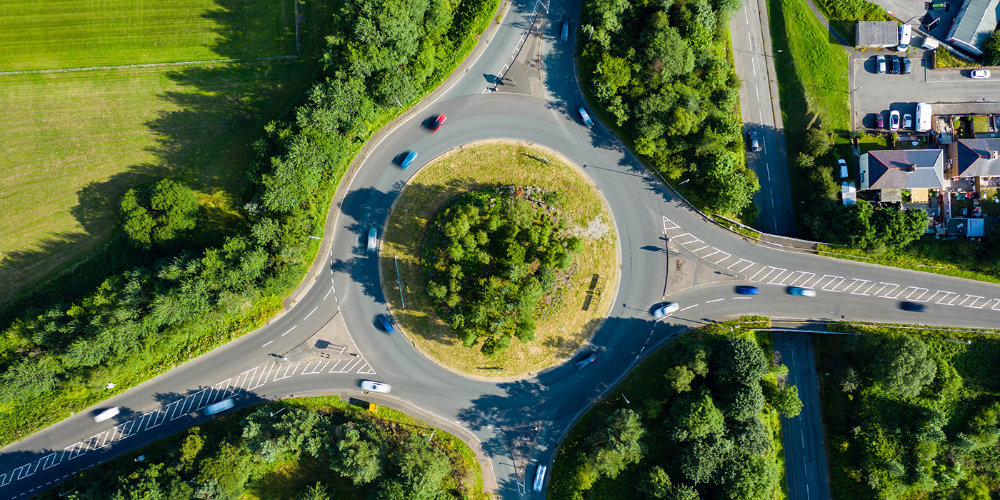 Aerial long exposure of traffic on a roundabout in a small town